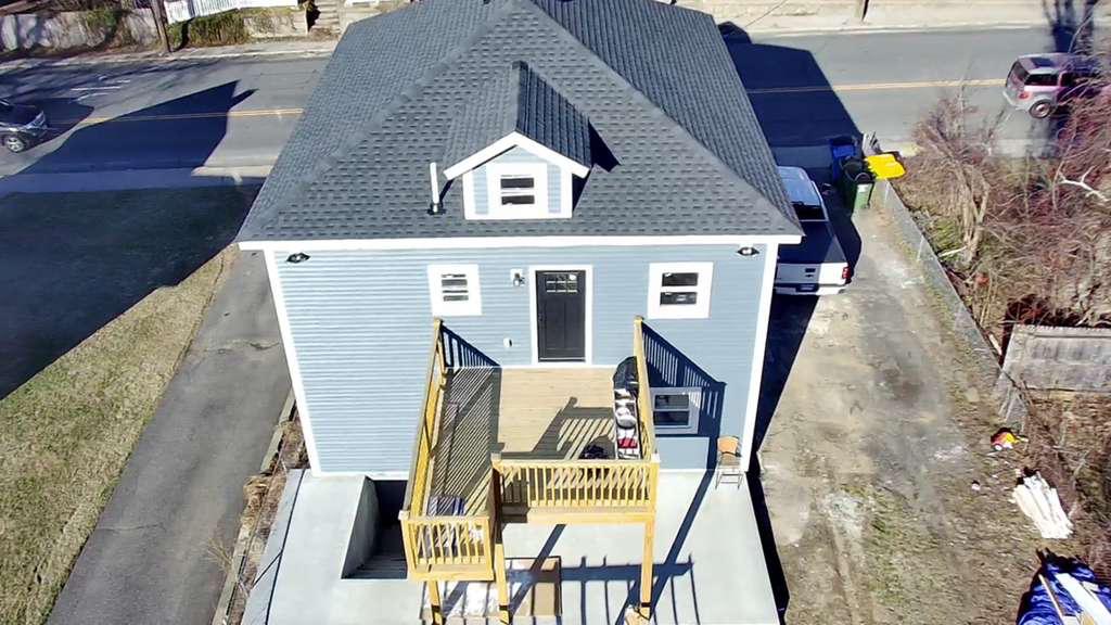 Exterior of a home with new roof and deck by M2J