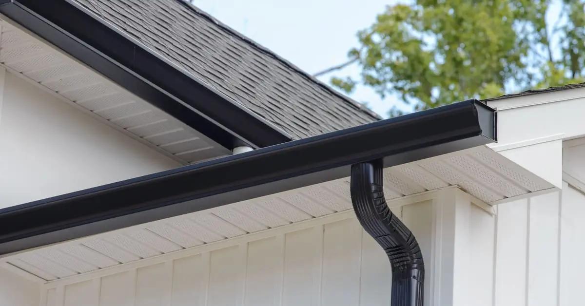 Close-up of a new dark seamless gutter installed on white fascia by M2J