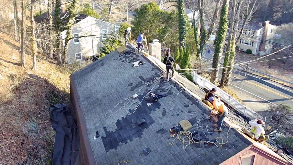 M2J Construction crew installing a new asphalt-shingle roof on a Connecticut home