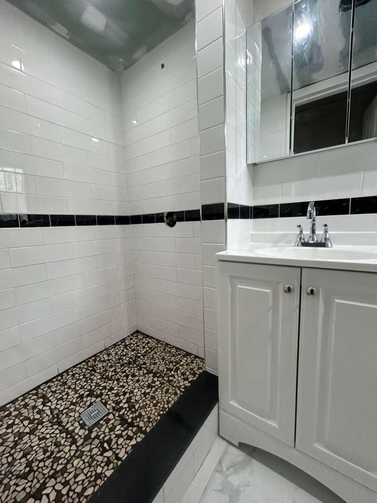 Remodeled walk-in shower with a pebble-stone floor