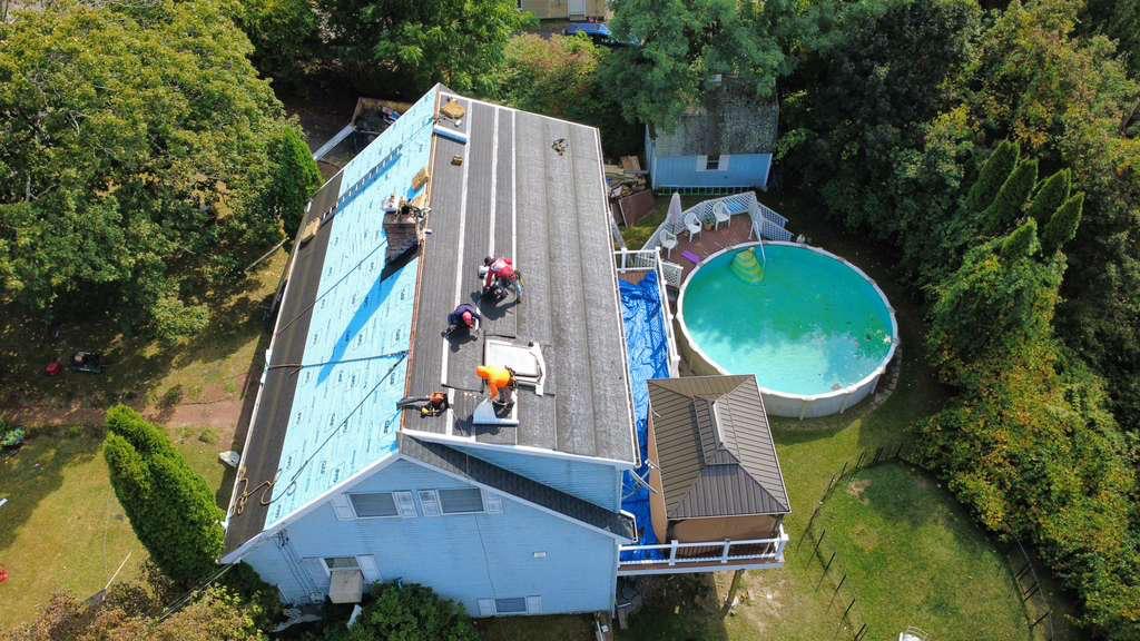 M2J crew re-roofing a home with a backyard pool