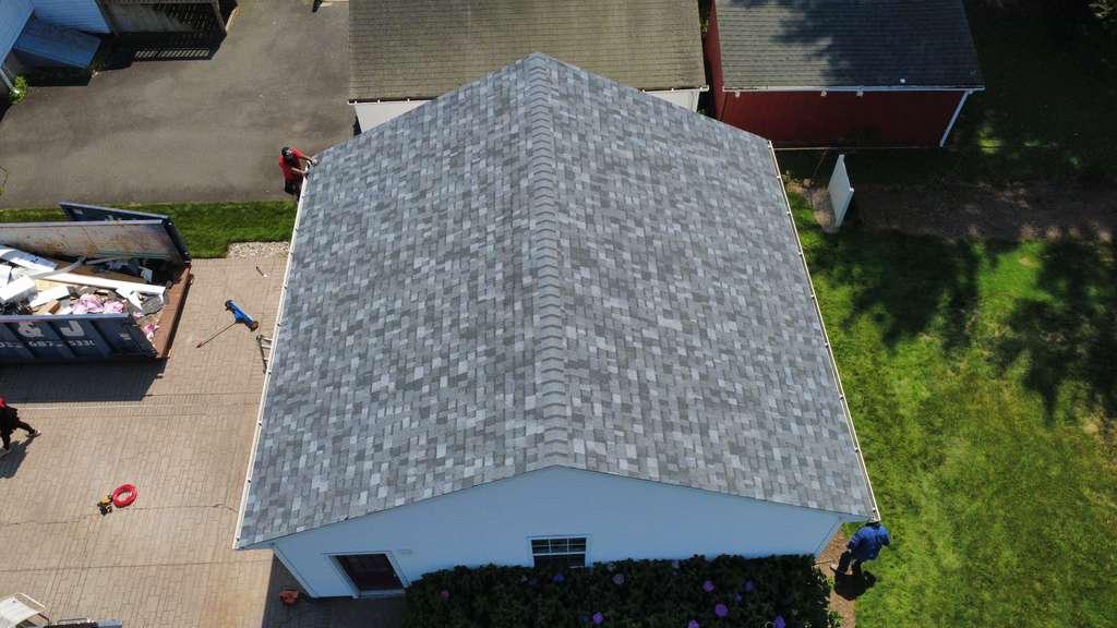 Aerial view of a freshly installed asphalt-shingle roof ridge on an M2J project